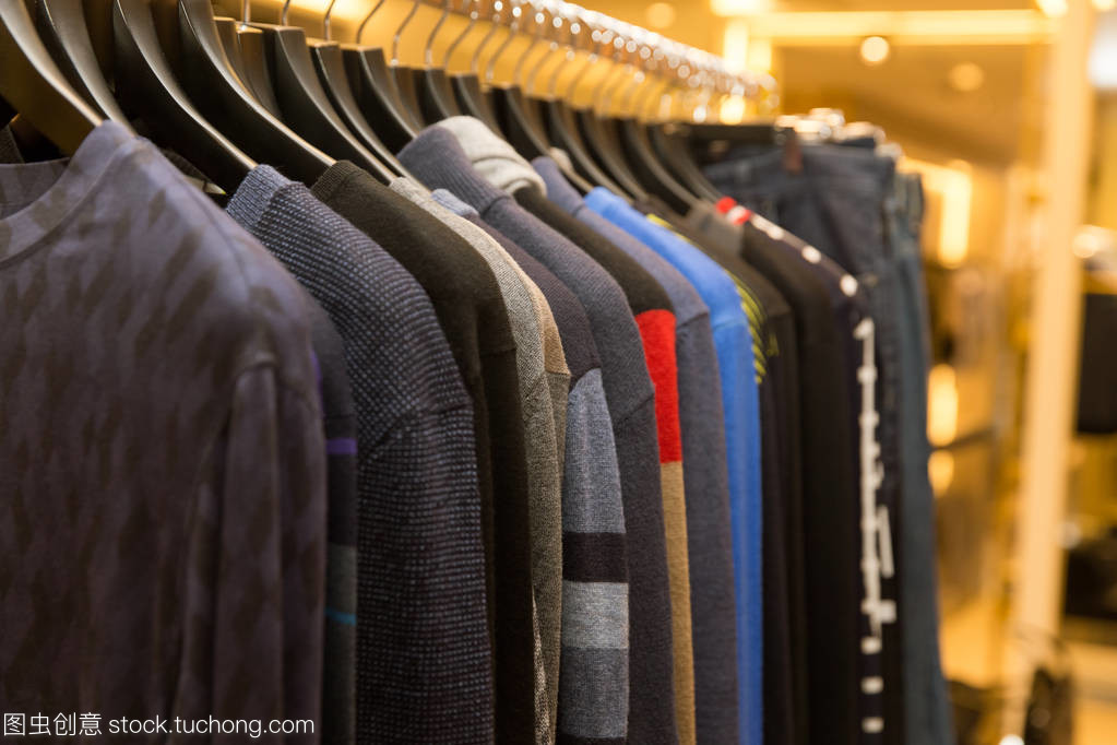 男子毛衣和衬衫衣架在服装零售商店不同颜色